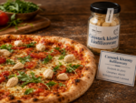 Pizza z liofilizowanym kiszonym czosnkiem Johny Catch jako chrupiacym dodatkiem, obok sloiczek produktu i karta informacyjna.