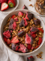 Granola z truskawką liofilizowaną i liofilizowaną czekoladą Johny Catch w ceramicznej misce, podana ze świeżymi truskawkami.