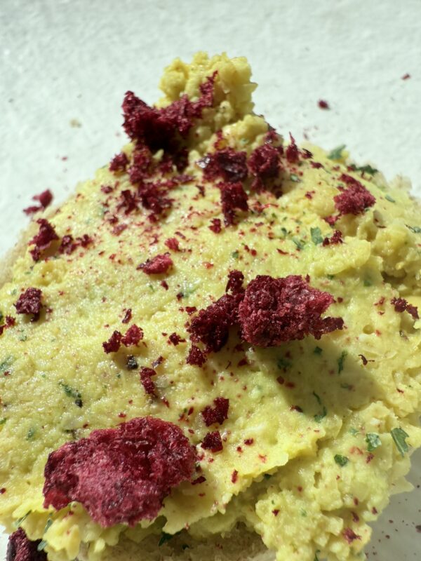 kanapka z kremową pastą z ciecierzycy, posypana pokruszoną lio wiśnią - zdrowa , kolorowa przekąskawspierająca czystą cerę i dobrą energię