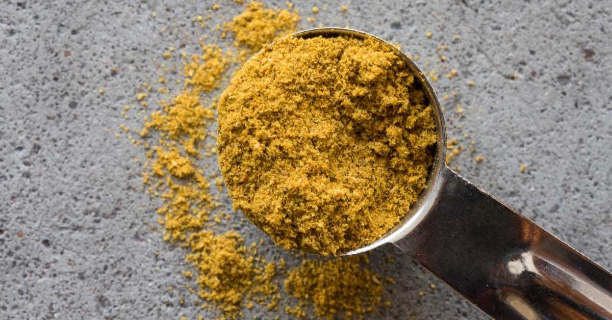 Proszek pochodzenia roślinnego odmierzany w metalowej łyżce – przykład formy żywności funkcjonalne